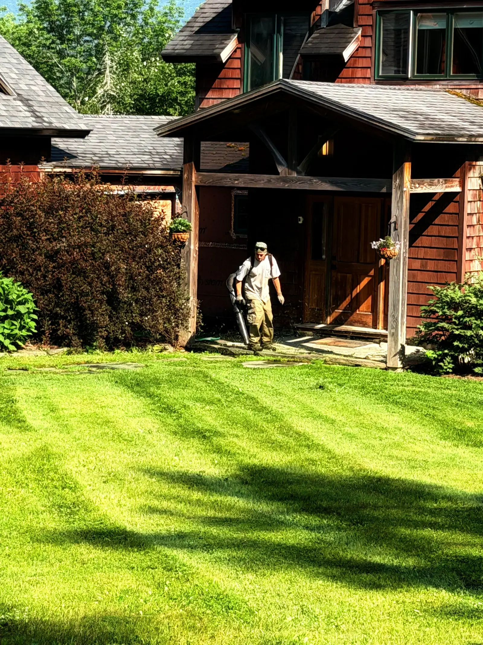 Cedar-shingled home behind a freshly striped lawn